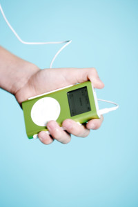 A hand holds a lime-green Apple iPod portable digital music player --- Image by © Royalty-Free/Corbis