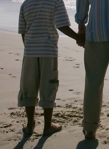 Young Couple with Two Children (8-12) Walking on the Beach --- Image by © Royalty-Free/Corbis